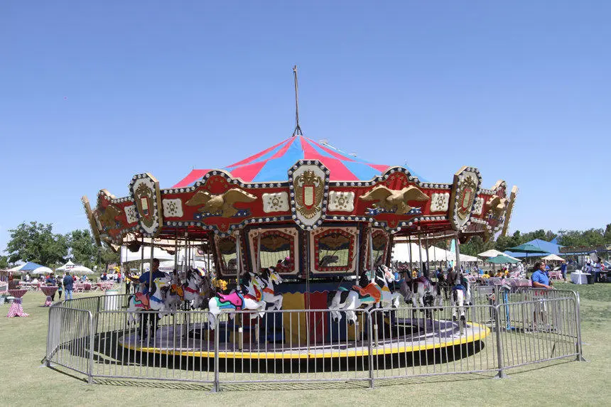 Classic Carousel Ride Red Blue Striped Canopy Gold Accents Outdoor Event Production Las Vegas
