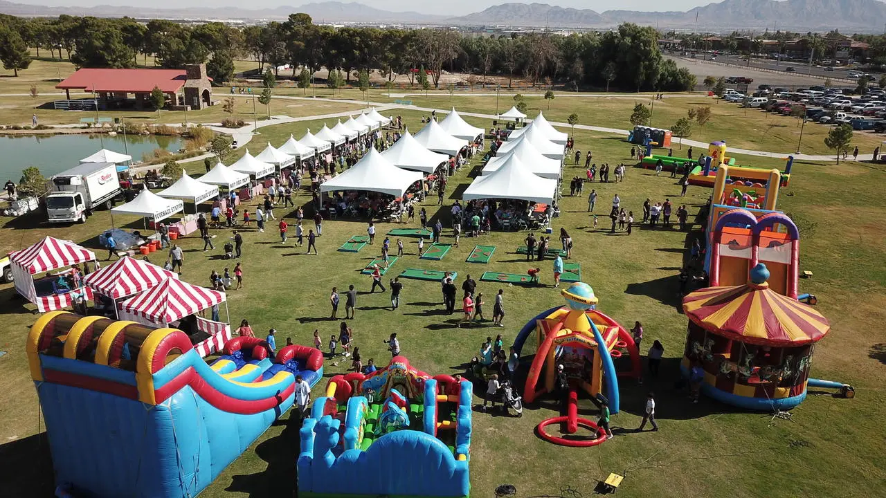 Aerial view of company picnic with inflatables, obstacle courses, tents, and pond in Las Vegas
