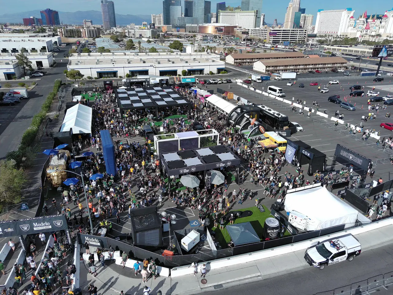 Aerial view of Raiders tailgate/fan zone with Modelo branding, tents, crowd