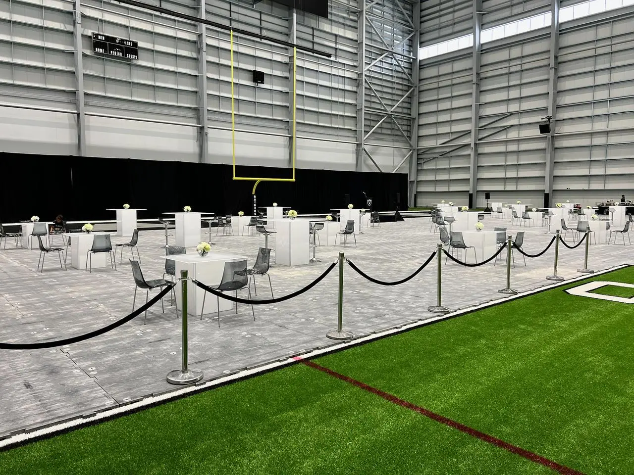 Las Vegas Raiders indoor facility event with tables, chairs, and temporary flooring
