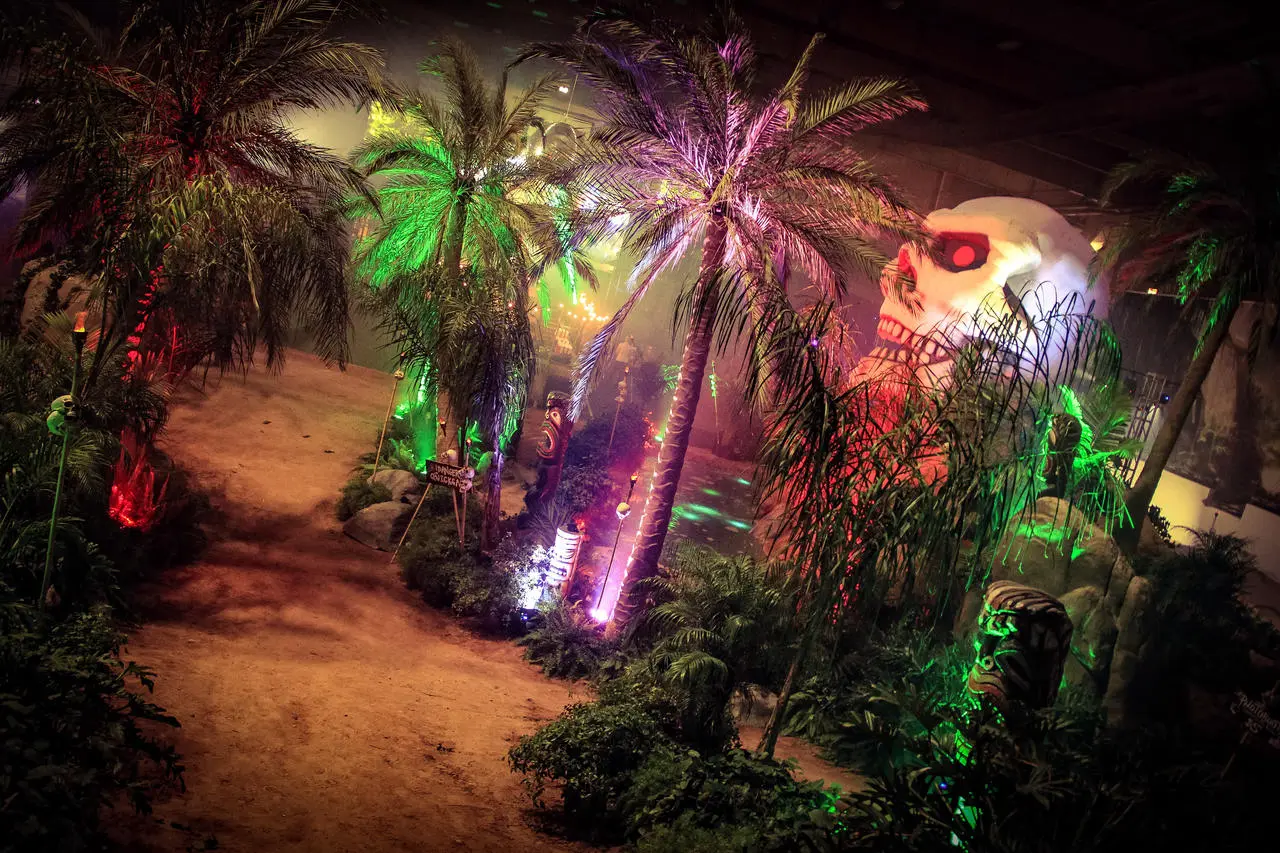 Tropical jungle themed event with palm trees, giant skull, and dramatic lighting in Las Vegas